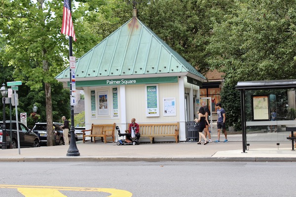 green-roofed newsstand with lamp post in front