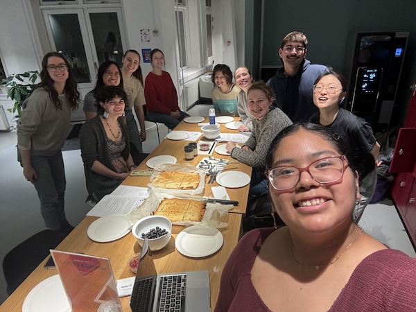 Students smiling at camera with a table filled with baking supplies. 